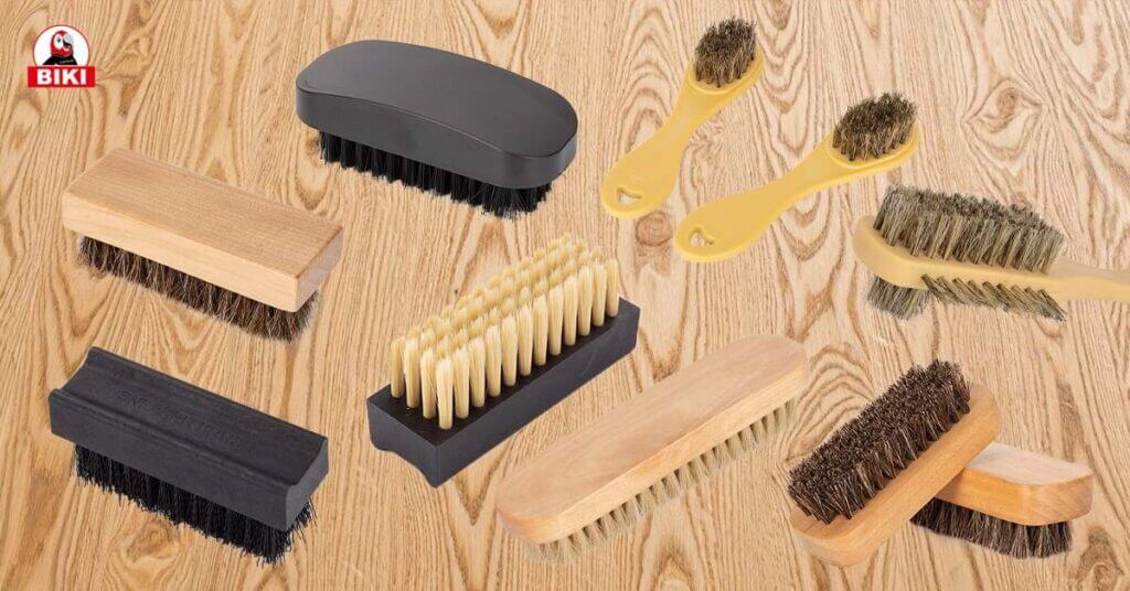 Assorted Biki Shoe Brushes for Leather Shoe Care Displayed on Wooden Background