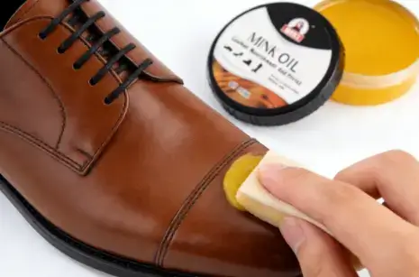 A-hand-conditioning-a-black-leather-shoe-with-mink-oil