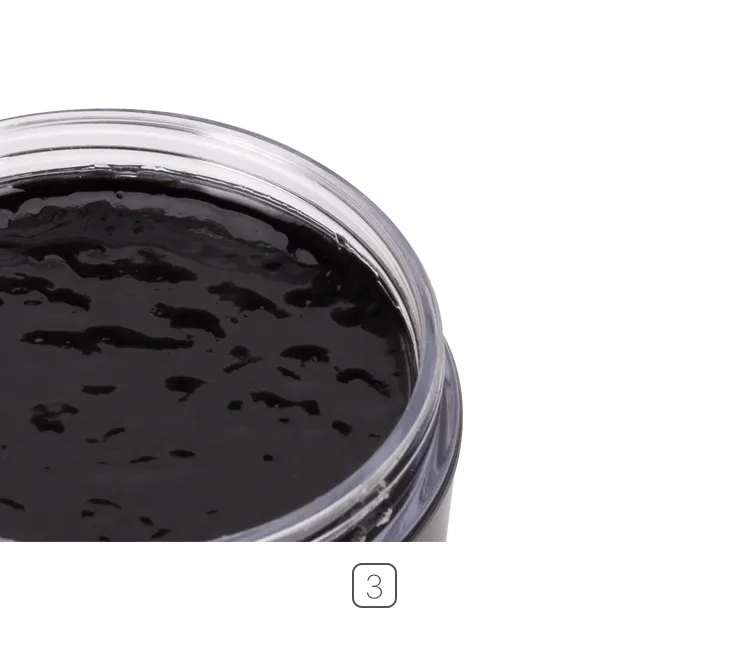 Close-up view of the glossy, textured surface of black solid shoe polish wax inside the jar.
